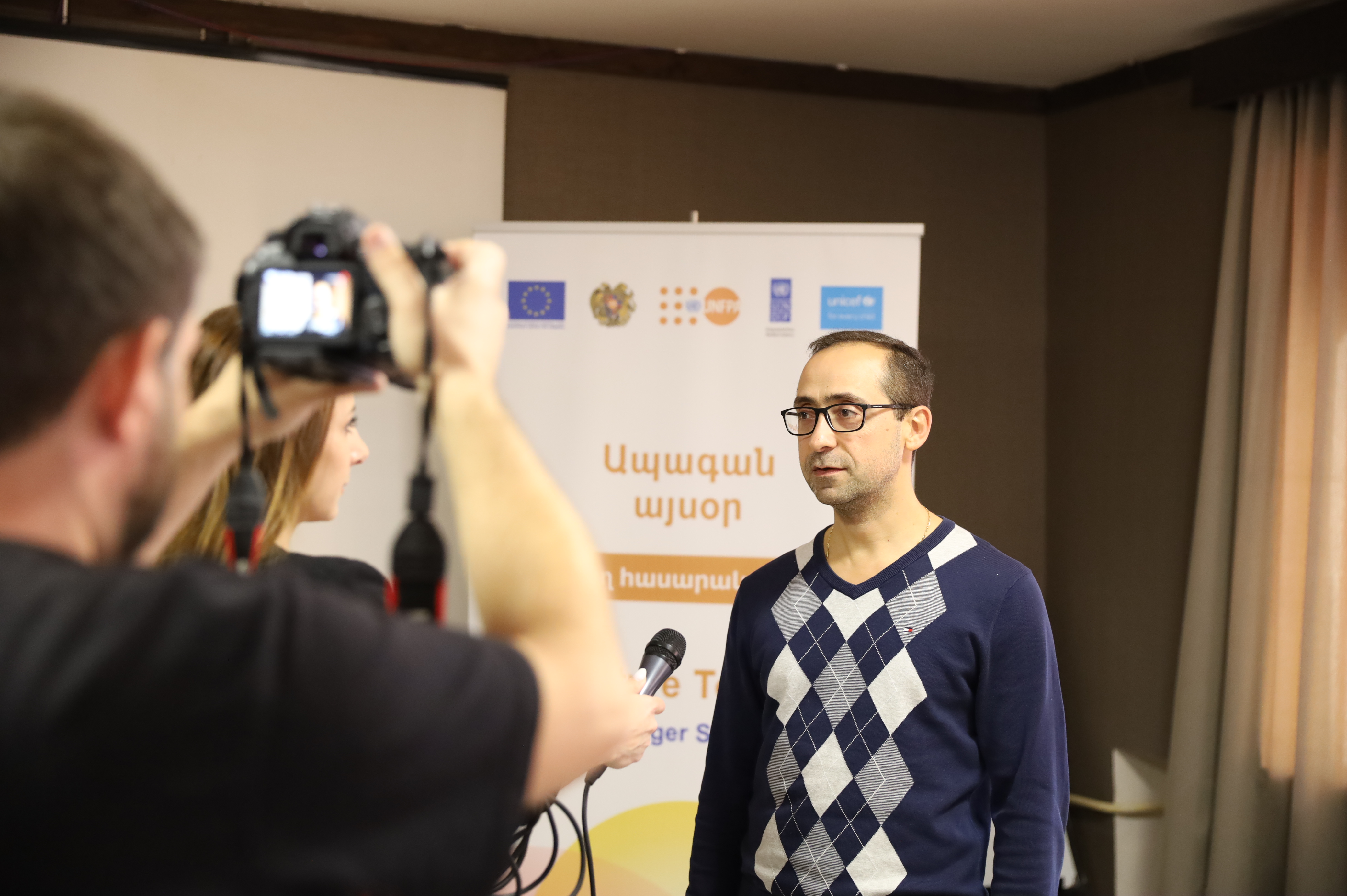 Eduard Israyelyan, Future Today Project Manager at UNFPA Armenia, speaking to the media in front of a project banner