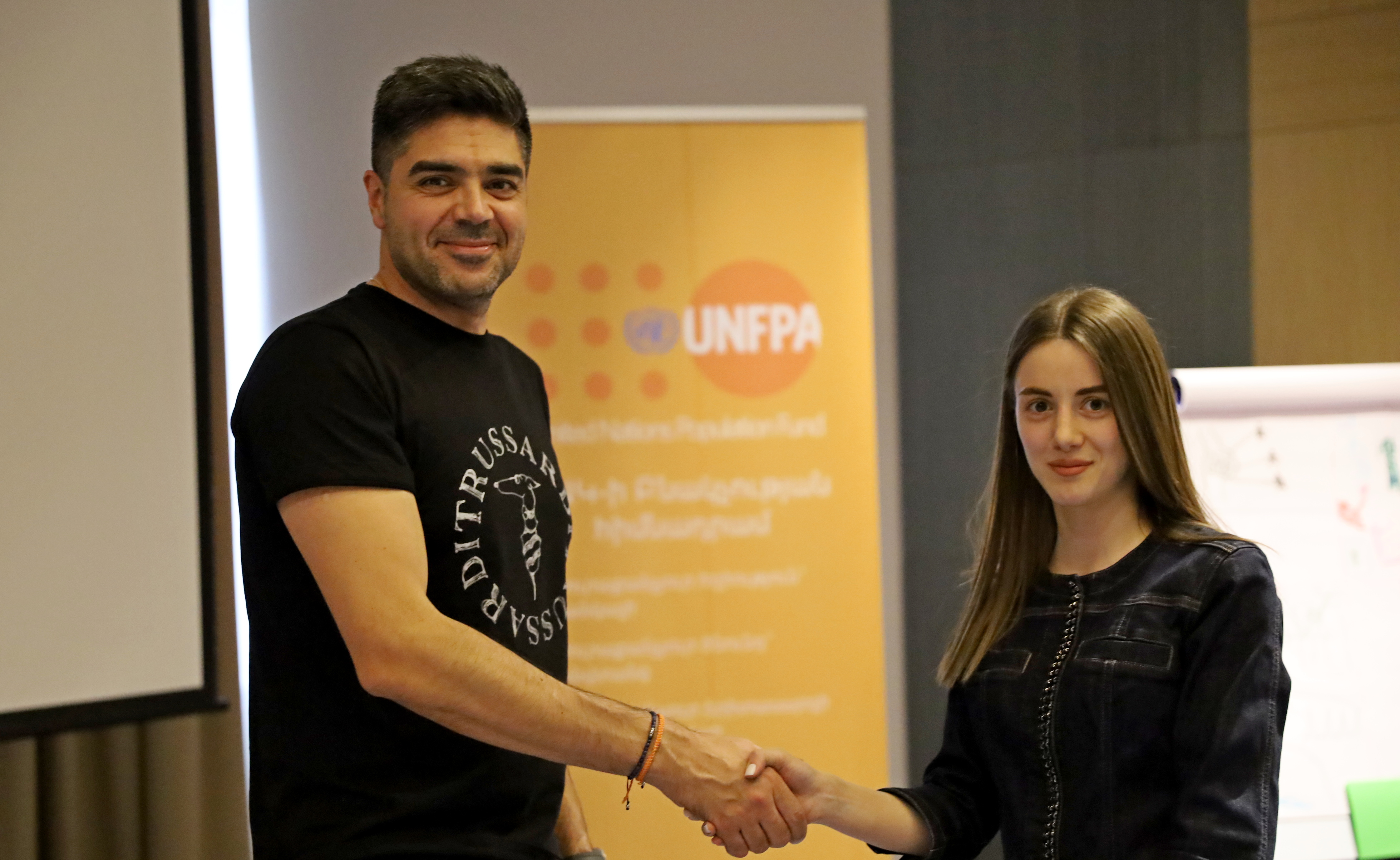 Vruyr Grigoryan hands over a certificate to the workshop participant.