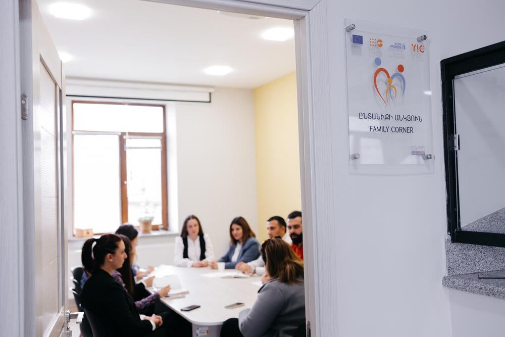 A group of professionals seated around a table during a meeting at the Family Corner center.