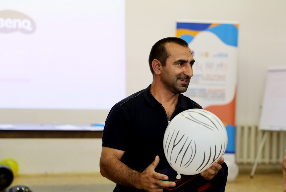 A man wearing a black shirt and holding a balloon during a fun game.