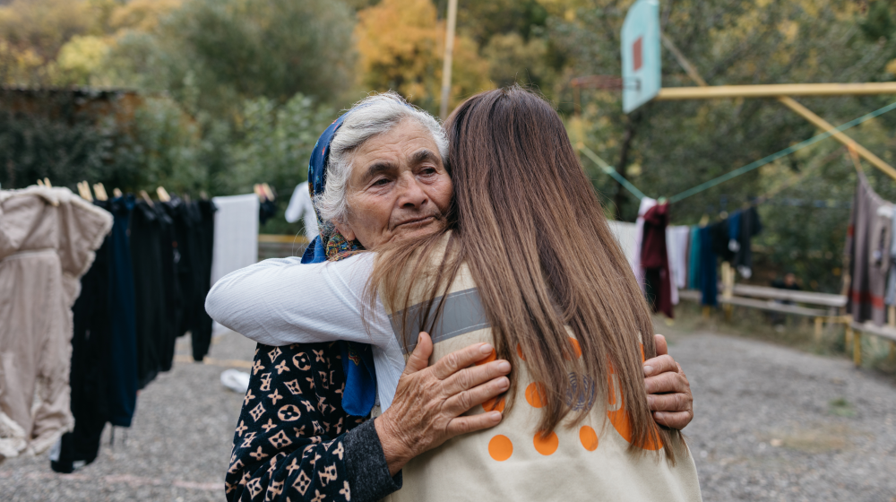 Refugee Melania Hayrapetyan, 74, hugs a UNFPA staff member.