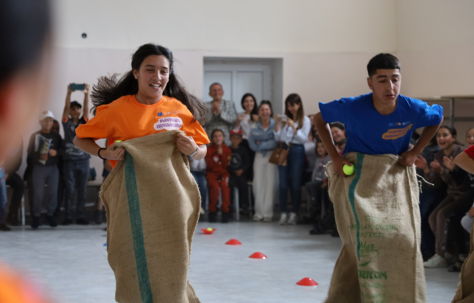 A girl and a boy competing in sack race