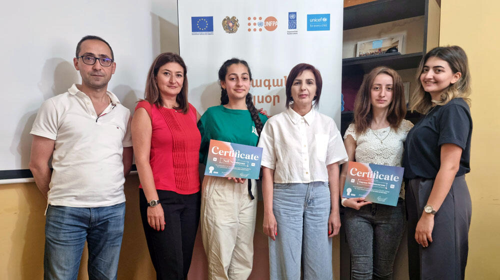 Two girls, two women and a man appear in the picture. Graphic design course participants receive their certificates